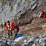Geological Team sampling mineralised tourmaline breccia lode emplaced along a thrust plane, Main Cirque.